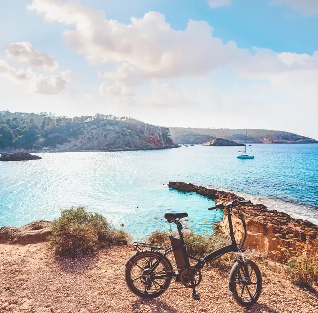 Mejores playas y calas de Ibiza -Cala Xarraxa, foto con una bici y la cala de fondo