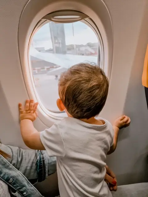 Viajar con un bebé - Eric mirando por la ventanilla del avión recién aterrizado en Pisa