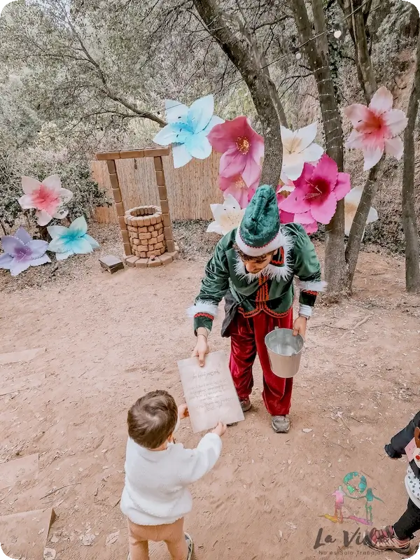 Un elfo le da un diploma a Eric dspués de solucionar el problema de la Navidad en el Bosc Màgic