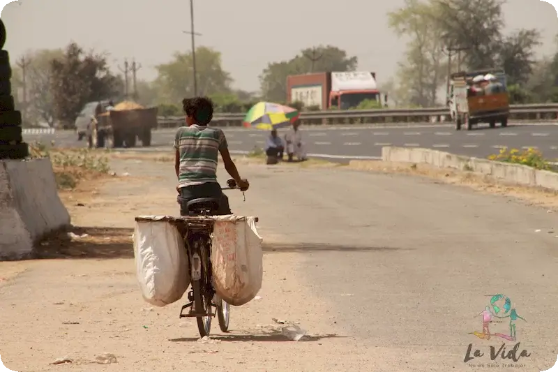 Niño en bici en autopista de la India