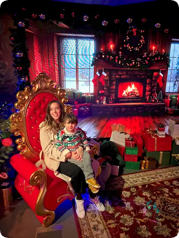 Judit en un sillón rojo con Eric, estilo Papa Noel. Casa Seat en Navidad Barcelona