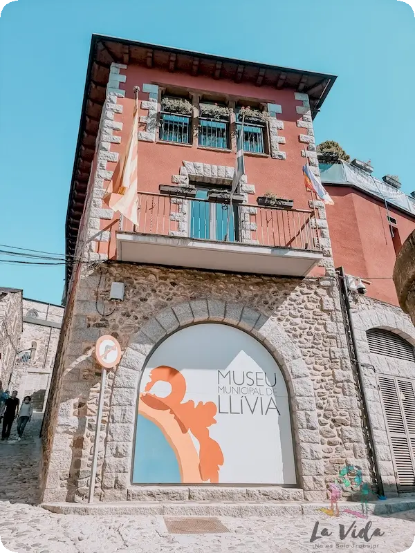 Foto de la fachada, edificio de color rojo, Farmacia Esteve, el Museo Municipal de Llívia 