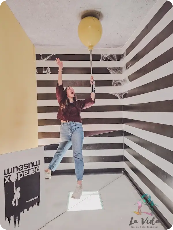 Judit que parece que vuela colgada de un globo amarillo en Paradox Museum Barcelona